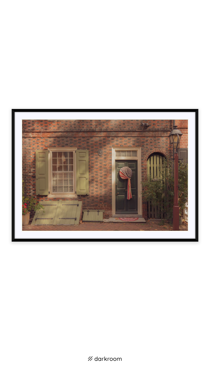 Black-framed print: A colonial door with a wreath and green shutters on Elfreth's Alley, Philadelphia